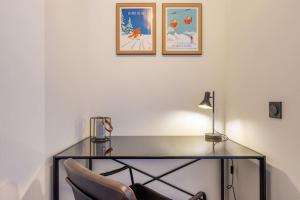 einen Glasschreibtisch mit einem Stuhl und einer Lampe in der Unterkunft Le Freney - New Apartment in Town Center & Free parking - By Cozee Rentals in Les Houches