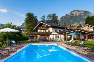 a swimming pool in front of a house at Gästehaus und Ferienwohnungen Egglerlehen in Schönau am Königssee