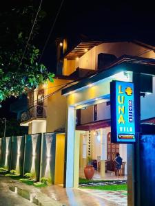 a sign in front of a building at night at Dikckwella Luna villa in Dickwella
