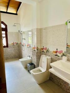 a bathroom with two toilets and a sink at Dikckwella Luna villa in Dickwella