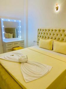 a bedroom with a large yellow bed with a large headboard at Dikckwella Luna villa in Dickwella