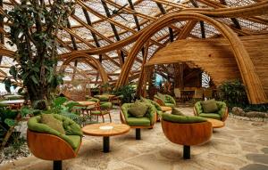 a room with green chairs and tables in a building at Nuanu Suites & Accommodations in Tanah Lot