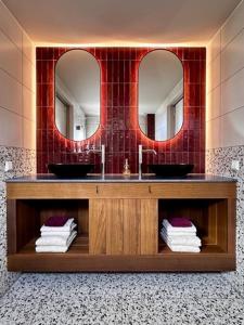 un baño con lavabo y dos espejos en Huisje zand zicht, en Wekerom