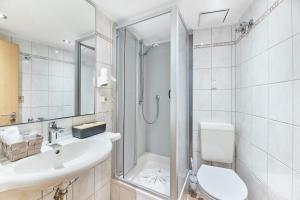 a bathroom with a shower and a sink and a toilet at Hotel Weinhof in Cochem +49 photos