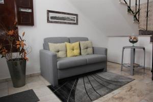 a gray couch with yellow pillows in a living room at Hospedaria A Italiana in Moura