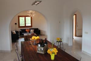 a living room with a wooden table with wine bottles at Villa Torre al Mar in Cala Santanyi