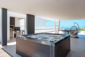 a living room with a large tub in the middle of a house at Casa Caracol, with a panoramic ocean view in Lourinhã