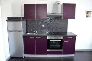 una cucina con armadi viola e lavandino di Apartments Mare a Baška