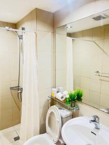 a bathroom with a toilet and a sink and a mirror at Alphas Haven in Manila
