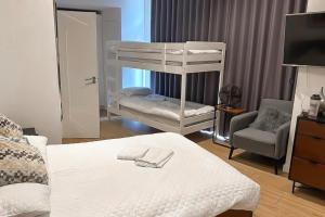a bedroom with two bunk beds and a chair at Sleep 6 Piccadilly Grand in London VR5 in London +6 photos