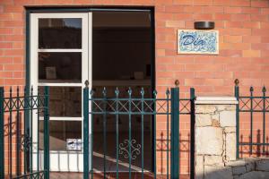 an open door of a brick building with a fence at Dia Apartments in Hersonissos