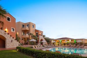 a resort with a swimming pool and chairs and buildings at Dia Apartments in Hersonissos