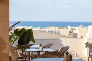 a patio with tables and chairs and a view of the ocean at Dia Apartments in Hersonissos