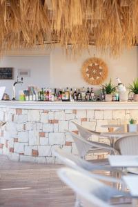 a bar with white chairs in a restaurant at Dia Apartments in Hersonissos