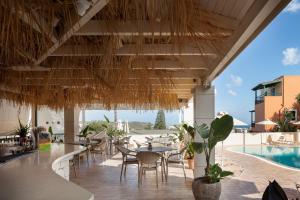 a restaurant with tables and chairs and a pool at Dia Apartments in Hersonissos