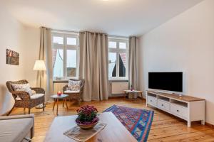 a living room with a couch and a tv at Im Herzen Templins Obergeschoss in Templin