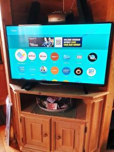 a flat screen tv sitting on top of a wooden cabinet at Ferienhaus Nr 14, Typ A, Feriendorf Jägerpark, Bayerischer Wald in Prackenbach