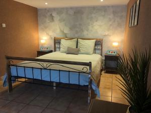 a bedroom with a bed with two tables and a plant at Maison M in Surin