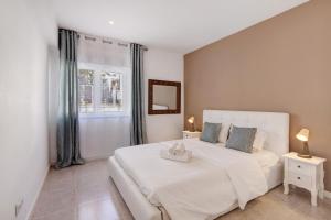 ポルシェスにあるApartamento Brisas Do Marの大きな白いベッドと窓のある寝室