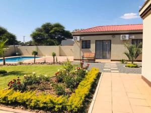 a house with a garden and a swimming pool at Pahotela Bed and Breakfast in Palatswe