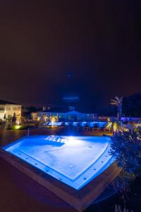 a large swimming pool at night with lights at Hôtel Les Grenettes in Sainte-Marie-de-Ré