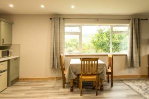 a kitchen with a table and chairs and a window at Taigh Geal Apartment in Portree +2 photos