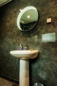 a bathroom with a sink and a mirror at Taigh Geal Apartment in Portree