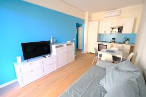 a living room with a couch and a tv and a kitchen at Perla Blu by PortofinoVacanze in Rapallo