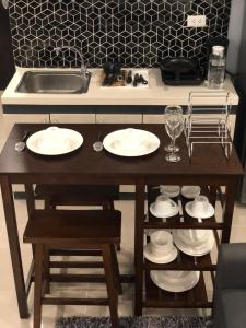 a table with plates and glasses and a sink at Kwartos Inn Building 101, 10th Floor ,Unit 1030 in Lo-oc +14 photos