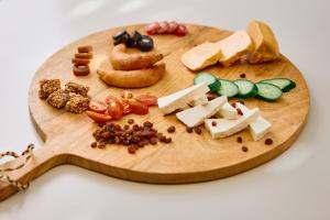 a wooden cutting board with different types of food on it at Nissi Park Hotel in Ayia Napa