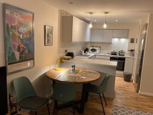 a kitchen with a wooden table and chairs in a room at The Art Flat Woodlands in Glasgow
