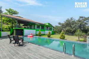 ナーシクにあるStayVista at Banyan Nirvana Villa with Pool, Bonfire & Lawnのプールと家のあるヴィラ