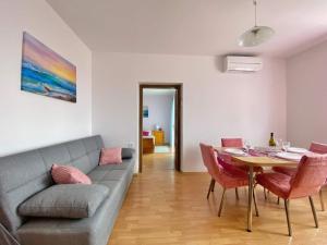 a living room with a couch and a table with chairs at Apartments Xenia Krk in Krk