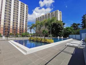 a large swimming pool with two tall buildings at Holiday Haven near Mactan Airport in Lo-oc