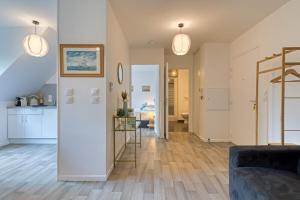 Il comprend un salon doté de murs blancs et de parquet. dans l'établissement Solent joli F2 proche Jardin des Plantes à Rouen, à Saint-Sever