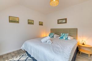 une chambre avec un grand lit blanc avec des oreillers bleus dans l'établissement Solent joli F2 proche Jardin des Plantes à Rouen, à Saint-Sever