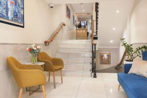 a living room with stairs and a table and chairs at Hotel Florence Nice in Nice