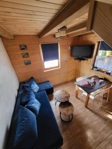 a living room with a blue couch and a table at DOMKI POD CHMURKĄ in Solina