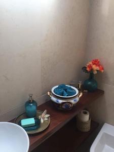 Un baño con un lavabo y un recipiente en un estante. en O Douro aqui tão perto, en Santo Adrião
