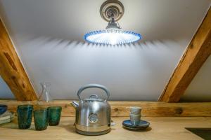 a tea kettle sitting on a wooden table with glasses at Kaszelewskiego1 in Zakopane
