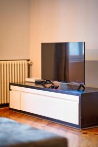 TV de pantalla plana grande en la parte superior de una mesa en Julie beau F6 rénové terrasse parking Rouen, en Grand-Couronne