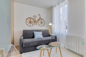 sala de estar con sofá y bicicleta en la pared en Léandre studio entièrement rénové avec extérieur, en Rouen