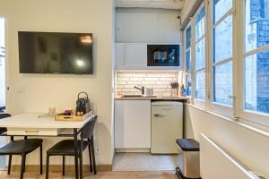 - une petite cuisine avec une table et un comptoir dans l'établissement Petit Vicomte joli studio place du Vieux Marché, à Rouen