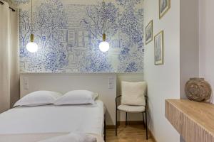 - une chambre dotée d'un lit avec du papier peint bleu et blanc dans l'établissement Petit Vicomte joli studio place du Vieux Marché, à Rouen