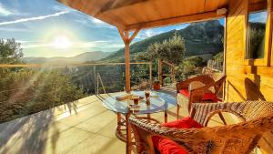 a patio with a glass table and chairs on a balcony at Cabaña 99 by Villamya in El Gastor