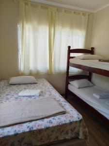 a bedroom with two bunk beds and a window at Flor de Jabuticabeira in Jaguariúna