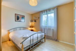 a bedroom with a bed and a window at L'Olivier charmante maison avec parking et jardin in Canteleu