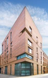 a large brick building with a triangular roof at Finlays Yard in Manchester