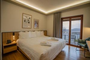a bedroom with a large bed and a balcony at Agnanti Limnis Hotel in Neochori