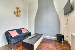 un soggiorno con un divano e un tavolo di Le Rêve doré proche de la Gare ! a Rouen